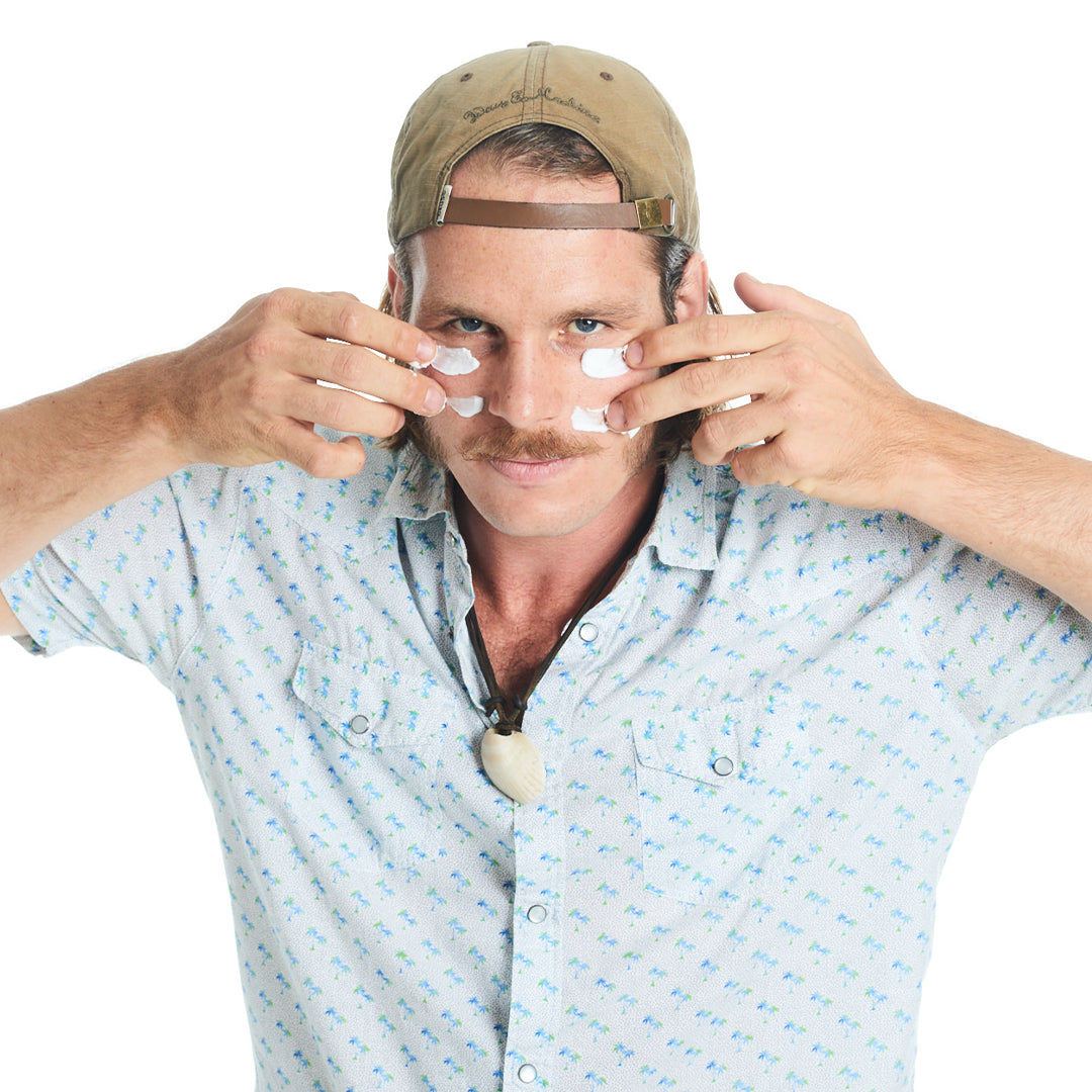 Man with Hat applying Cream to face